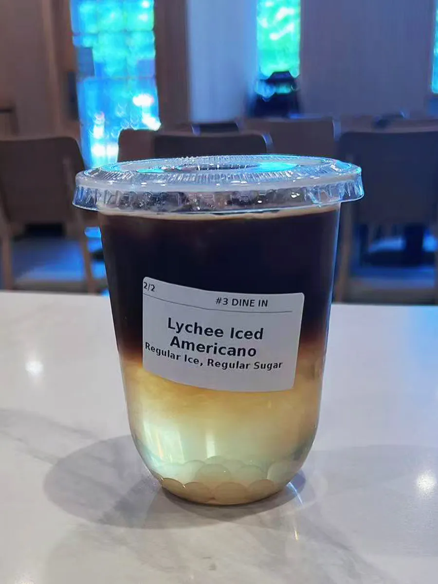 Layered lychee iced Americano coffee drink at Mochi & Crunch Treats, a Modern Dessert Café in Tupelo