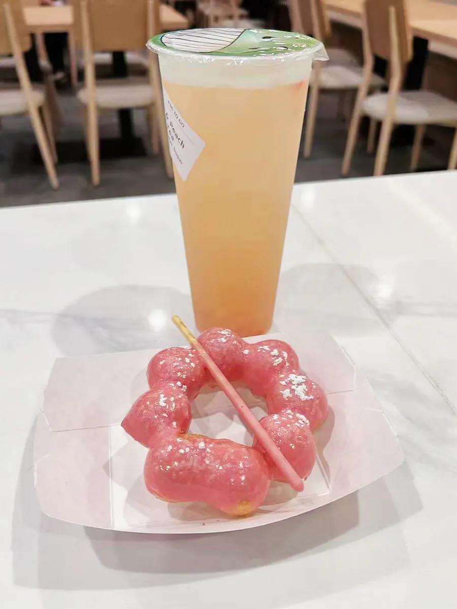Peach fruit tea with pink mochi donut at Mochi & Crunch Treats, a Modern Dessert Café in Tupelo