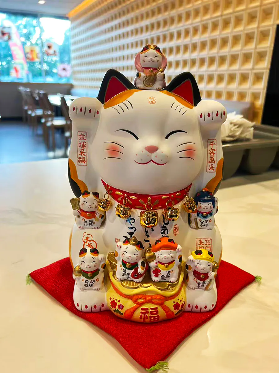 Charming multi‑kitten maneki neko lucky cat decor at Mochi & Crunch Treats, a Modern Dessert Café in Tupelo